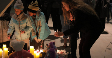 Standard Examiner photo of children and woman lighting candles