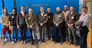 group of people standing in front of Boeing logo