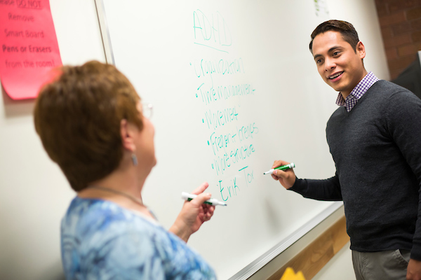 Image of two professors in front of a classroom