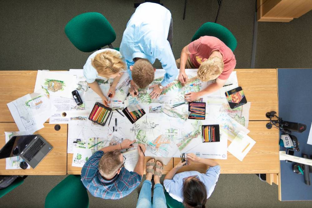 People huddled around a table looking at paperwork