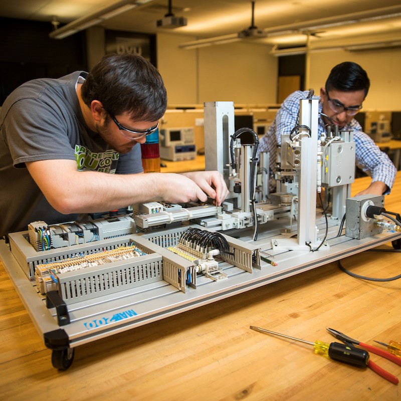 Students in a tech lab, working on machinery