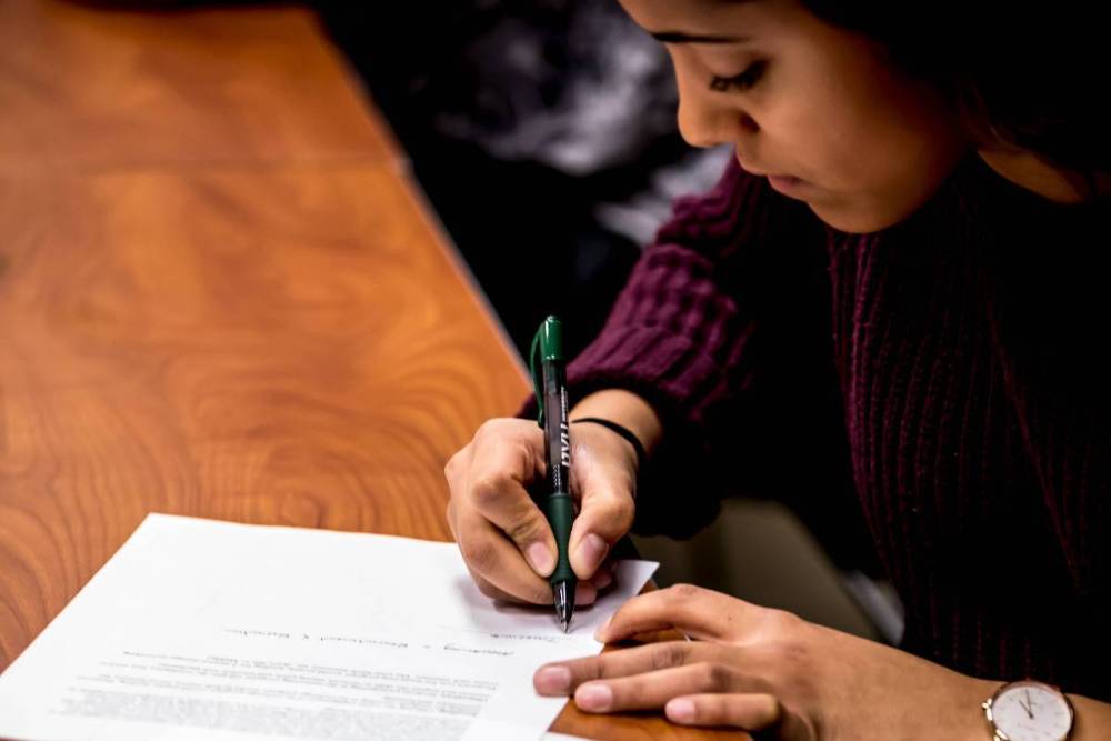 Student writing on paper