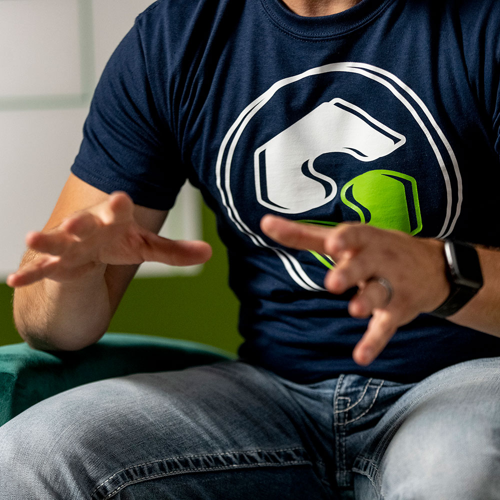 Close up of a man in a blue shirt talking with his hands