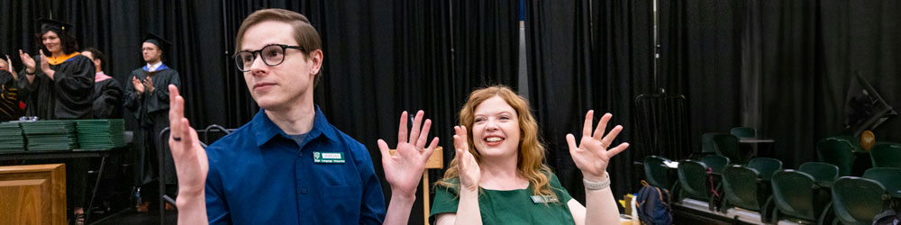 A male and female cheering in sign language