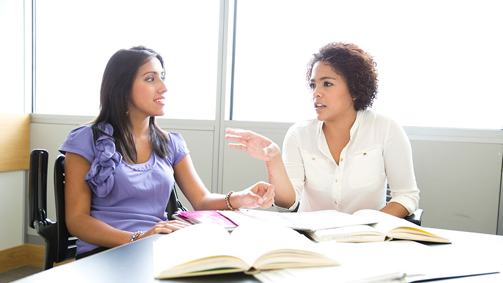 Two women seated at a table talking