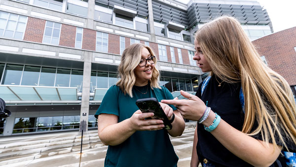 people discussing something they are looking at on a cell phone