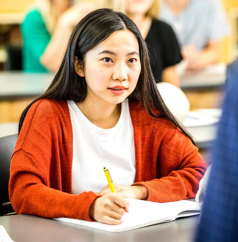 Student in a classroom taking notes