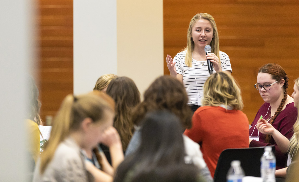 woman speaking in front of audience