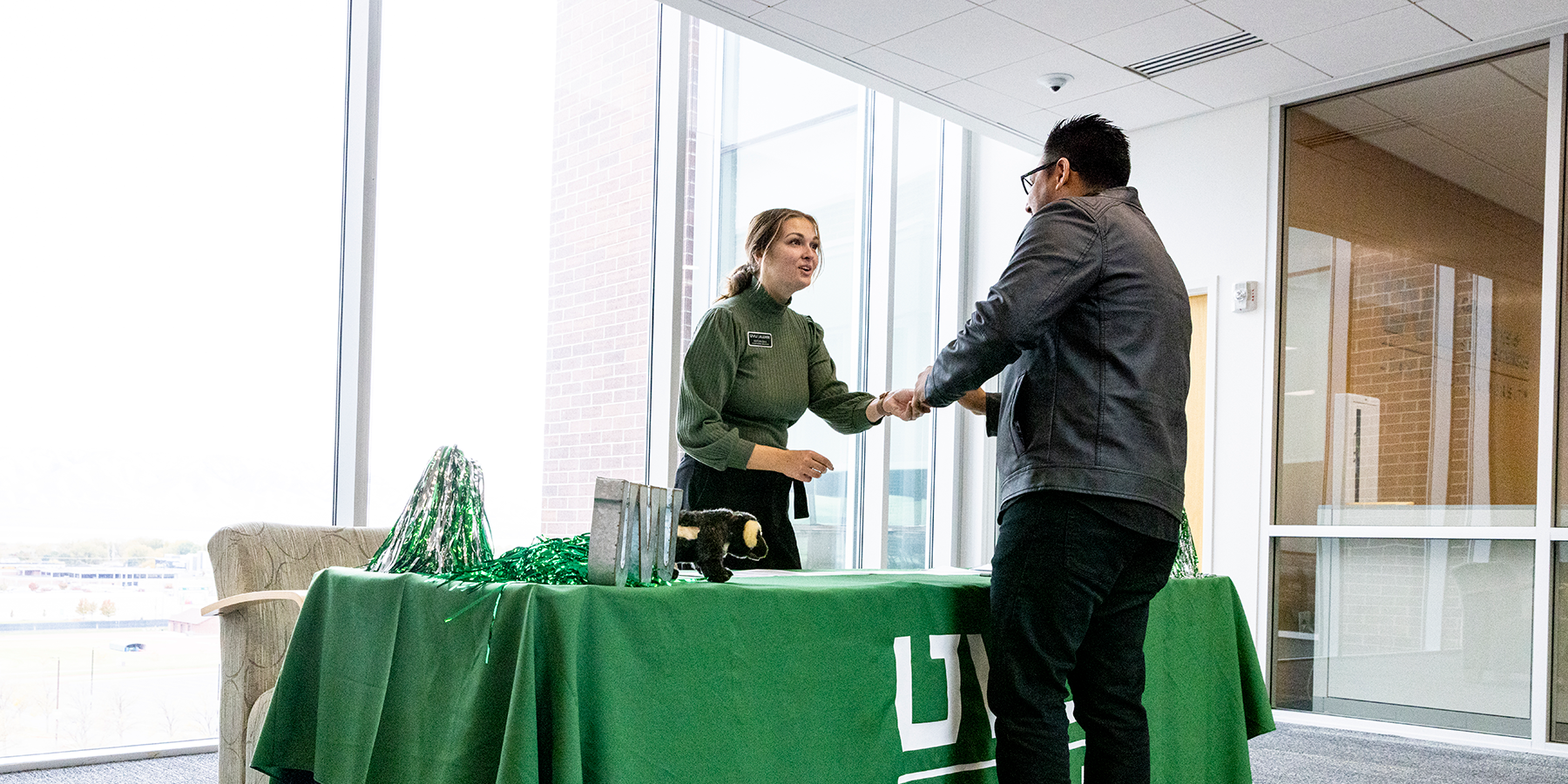 Two people shaking hands over a table