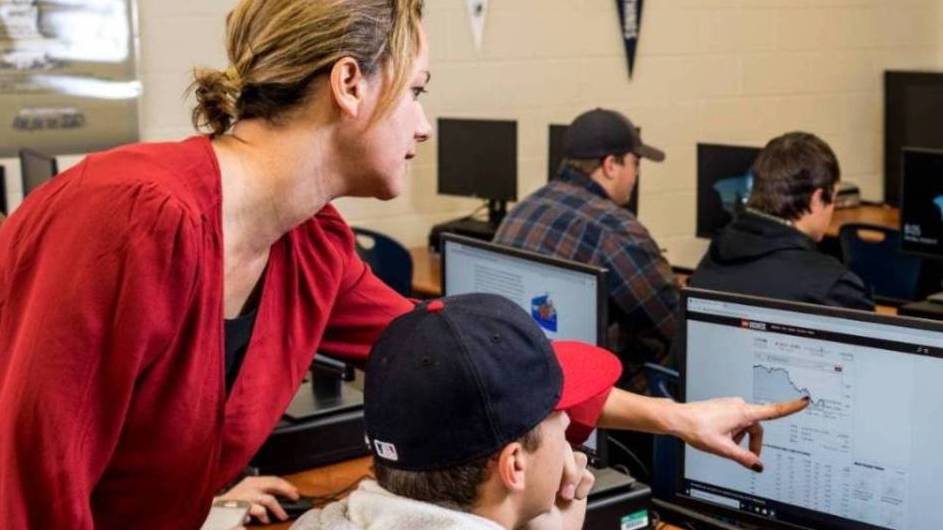 teacher helping student on the computer