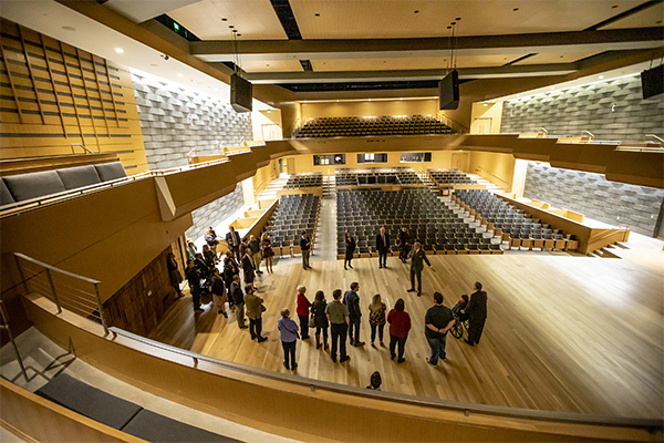 A group meets in a concert hall at the Noorda Center