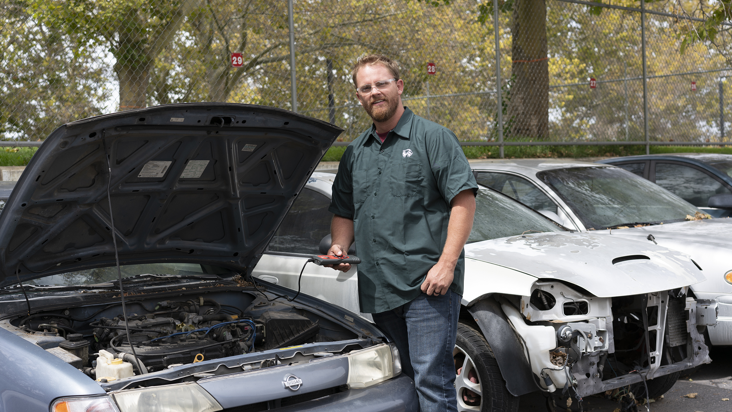 Tyler Robbins with a car that is being worked on