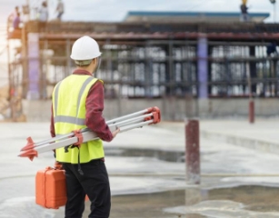 person holding surveying equipment 