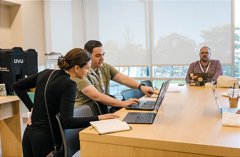 Teammates Katie Grow, Vin Jones, and Jac Madsen work through lunch during the HITLAB Hackathon