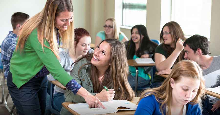 Teacher in classroom interacting with students.