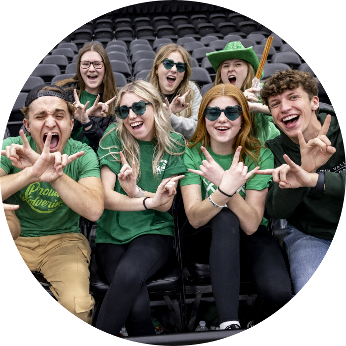 Students sitting in the stands doing the UVU sign