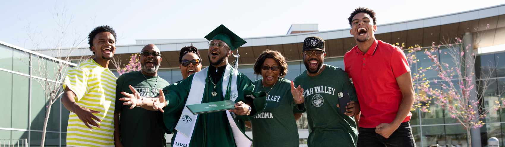 2023-24 Student Alumni Ambassadors smile and post with a UVU flag and pompoms.