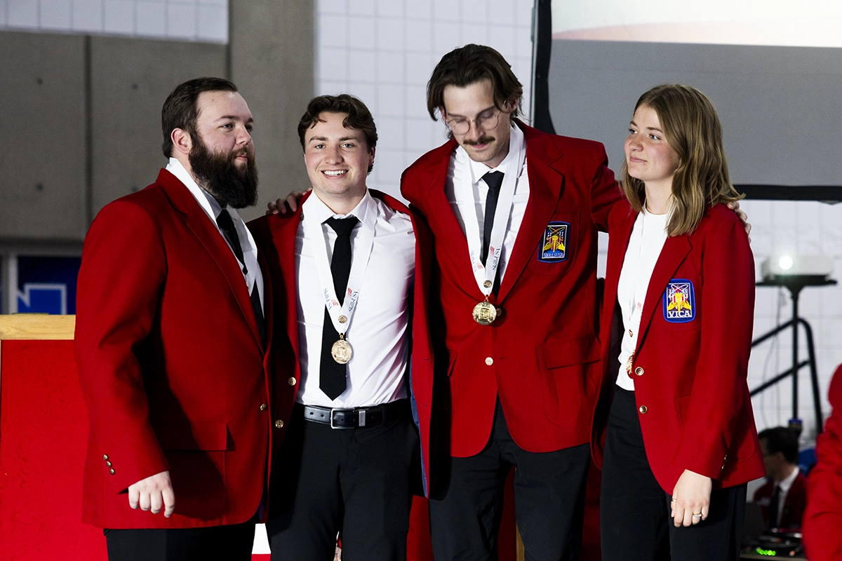 Four SkillsUSA students, wearing red blazers and medals, pose together at an event in Atlanta. Four SkillsUSA students, wearing red blazers and medals, pose together at an event in Atlanta.