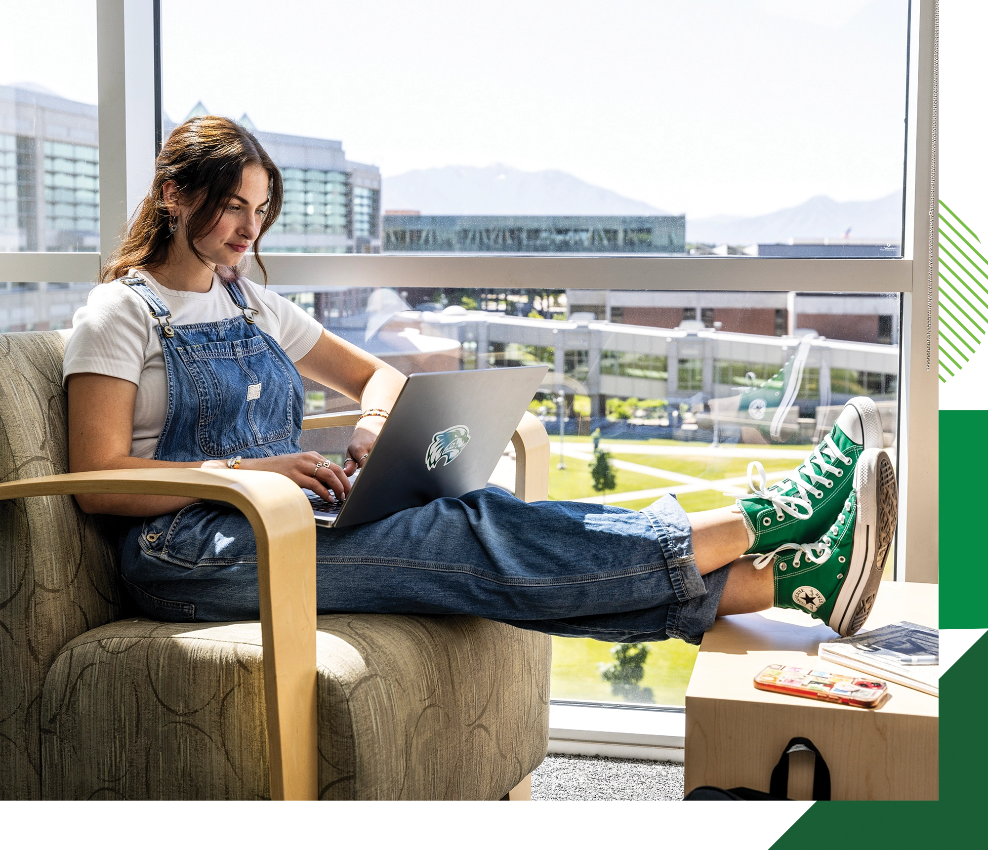 A student wearing denim overalls and green Converse sneakers studies on her laptop in a chair overlooking the Fulton Library quad on UVU’s Orem Campus. A student wearing denim overalls and green Converse sneakers studies on her laptop in a chair overlooking the Fulton Library quad on UVU’s Orem Campus.