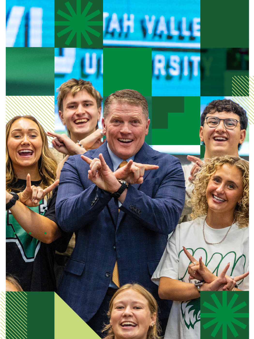 UVU President Jon Anderson poses with several UVU students, all making the Wolverine symbol with their hands. 