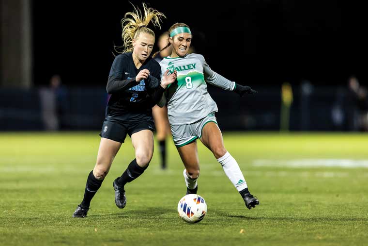 Action shot of Utah Valley women’s soccer team on the field during a game. 