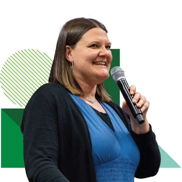 Wearing a blue blouse and a black cardigan, Alexis Palmer, UVU associate vice president of student development and well-being and dean of students, speaks into a microphone. Wearing a blue blouse and a black cardigan, Alexis Palmer, UVU associate vice president of student development and well-being and dean of students, speaks into a microphone.