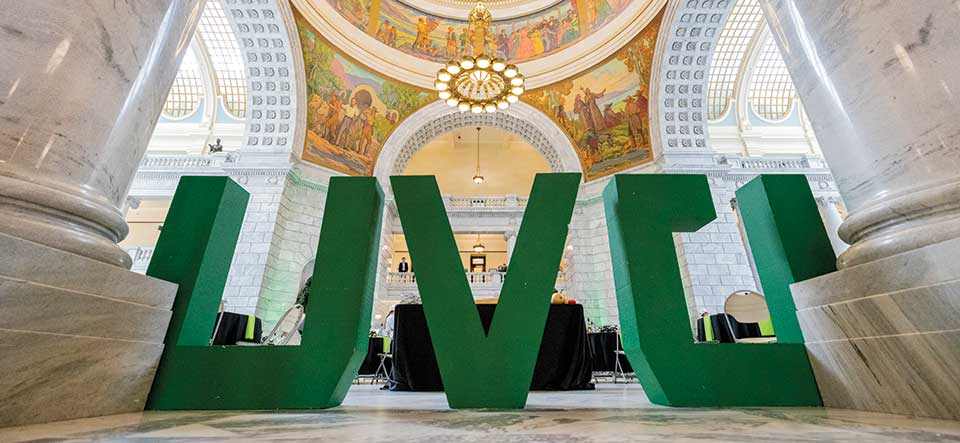 Photo of large green UVU letters in the rotunda of the Utah State Capitol Building. 