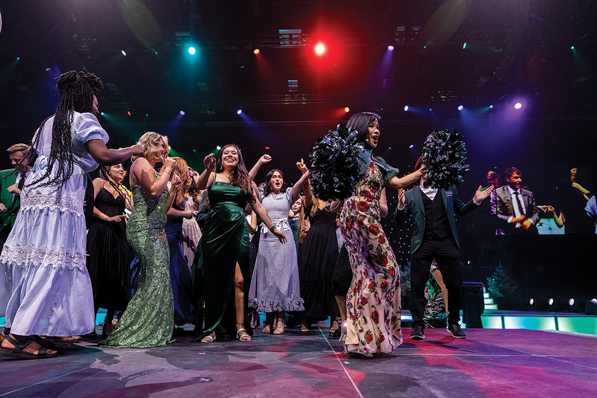Holding pom-poms, President Tuminez dances on stage with the presidential interns during the 2024 President’s Scholarship Ball. Holding pom-poms, President Tuminez dances on stage with the presidential interns during the 2024 President’s Scholarship Ball.