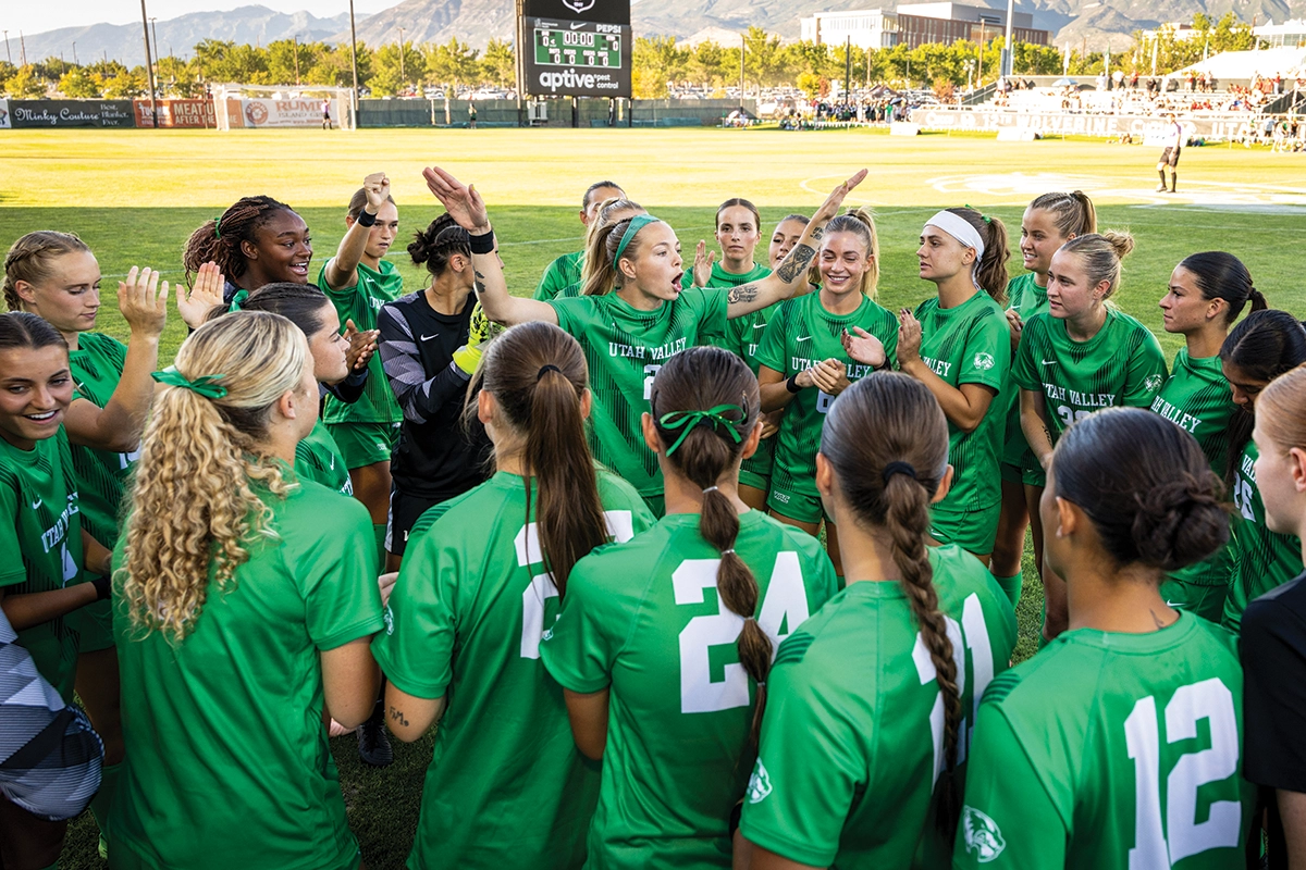 The UVU women’s soccer team, wearing green UVU jerseys, huddles on the field at the new UCCU Stadium. The UVU women’s soccer team, wearing green UVU jerseys, huddles on the field at the new UCCU Stadium.