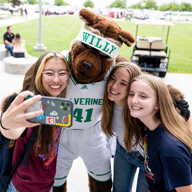 Willy takes a selfie with 3 students.