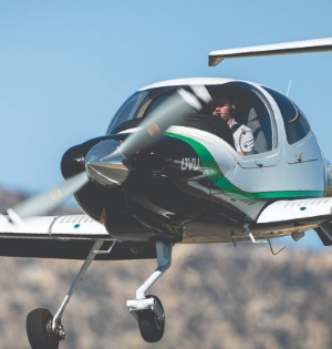 A student from UVU’s Aviation Program flies a small green and white airplane. 