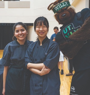 UVU Culinary Arts students pose with Willy the Wolverine during a Latinos of Tomorrow Summer Bridge Program event.
