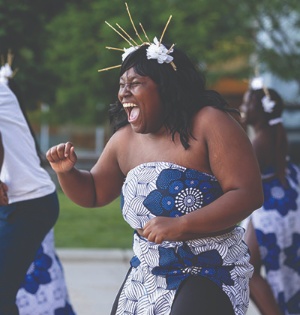 Students in blue and white floral dresses dance during UVU’s Juneteenth celebration in June 2023.