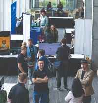 Photo of students and others interacting with booths and presentations during the Silicon Slopes Artificial Intelligence Summit in June 2023.