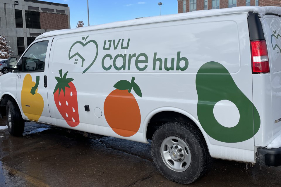 Photo of the UVU CARE Hub van, which is white and has graphics of fruit and vegetables on it. 