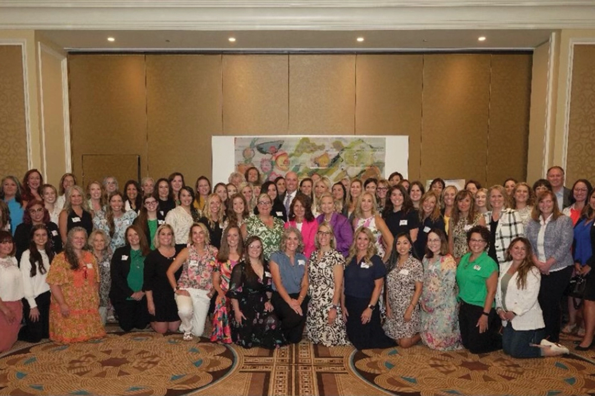 A large group of women pose together at an event celebrating the fact that Utah Governor Spencer Cox recognized UVU as one of the 100 Utah-based businesses championing women. 