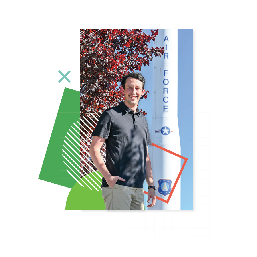 UVU alumnus Kayson Christensen poses for a photo with a U.S. Air Force rocket in the background on Utah’s Hill Air Force Base. 