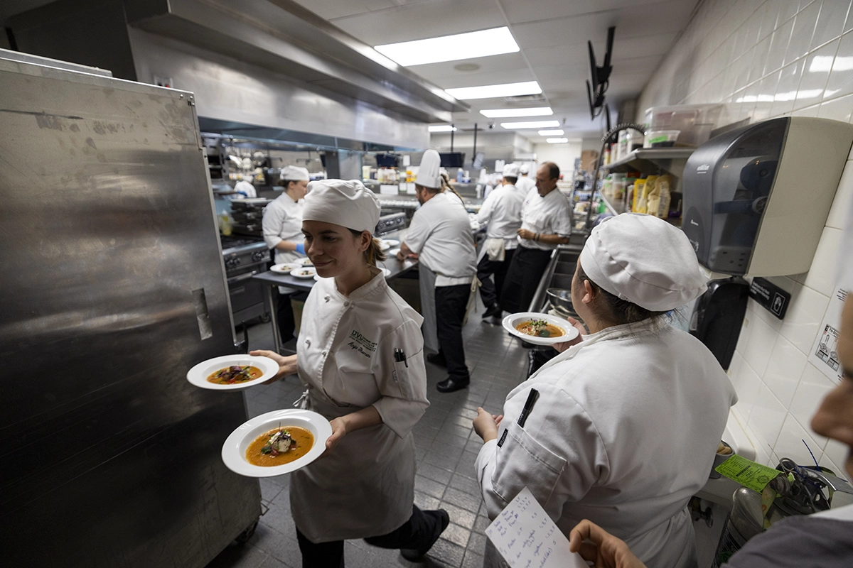 Culinary Arts students prepare food at an event. Culinary Arts students prepare food at an event.