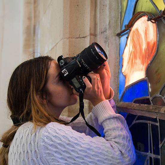 Photography student taking a picture of stained glass