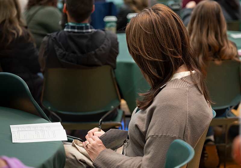 Image of an attendee writing at the conference.