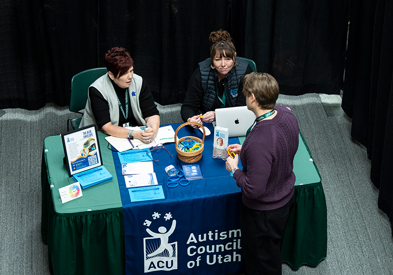 Image of attendees talking to people at a booth.