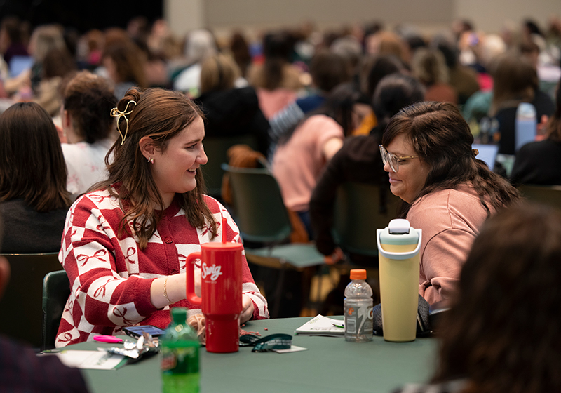 Image of attendees talking at a table.