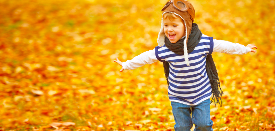 Child running through leaves