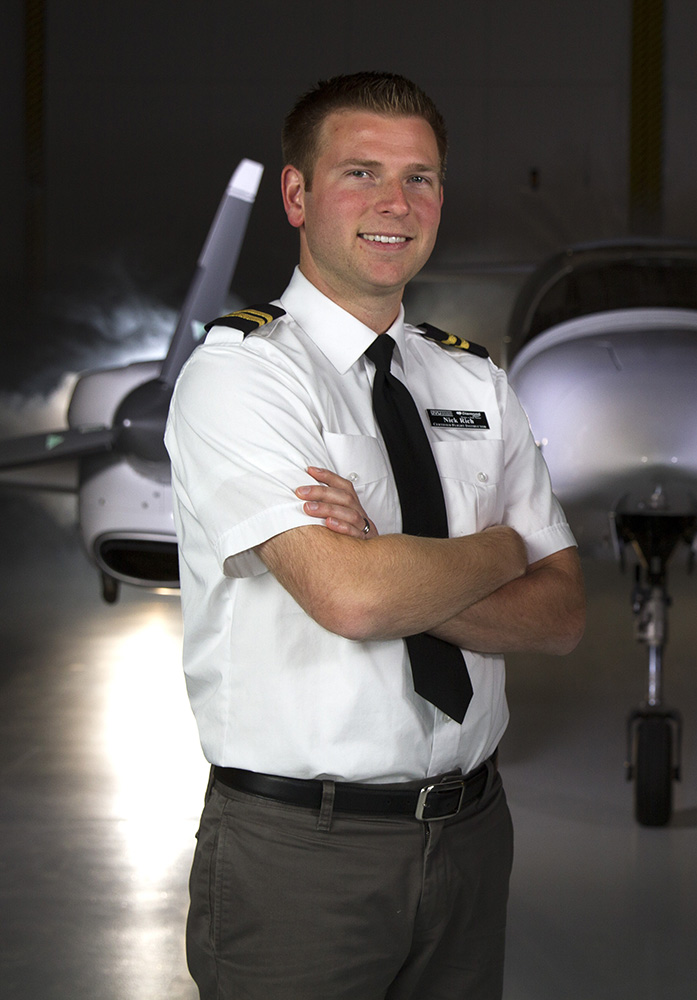 Male flight instructor standing in front of da-42 airplane
