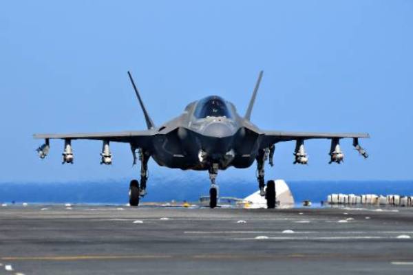 A military jet rests on a landing strip