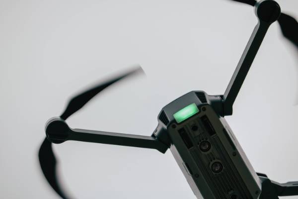 a drone floats in front of a gray background