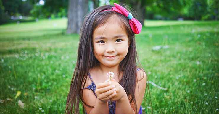 A little girl holding a flower. 