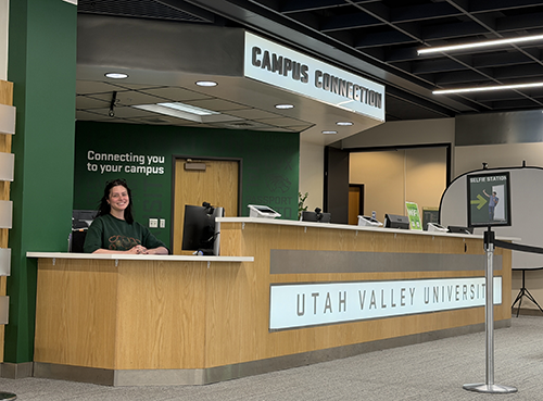 Campus Connection desk with a female staff member smiling and waiting to assist Campus Connection Location