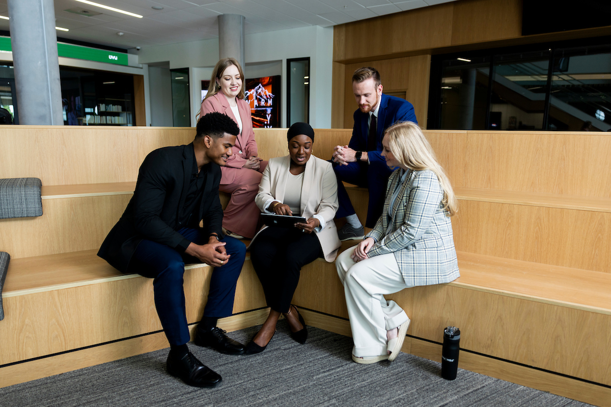 Coworkers seated around a laptop