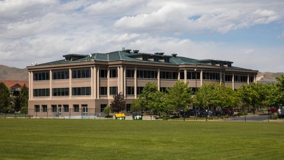 A senic picture of a building with the mountains in the background